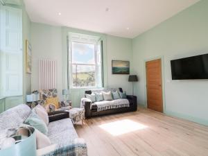 un salon avec un canapé et une télévision dans l'établissement Beachcomber, à Ballycastle