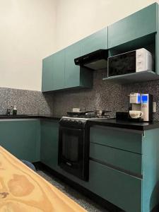 a kitchen with green cabinets and a stove at 107 SUITES DONCELES CENTRO HISTÓRICO CDMX in Mexico City