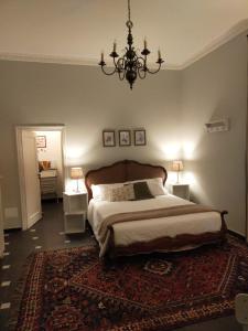 Un dormitorio con una cama grande y una lámpara de araña. en Dimora Caffaro en Génova