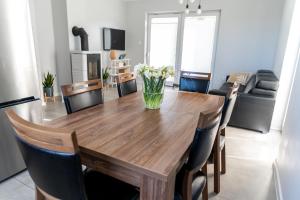 una mesa de comedor con un jarrón de flores. en Siedlisko pod brzozami, en Sasino