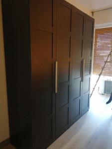 a large closet with wooden doors in a room at La maison de Amelie in Lecce