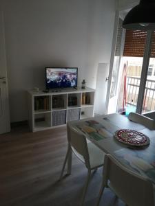 a living room with a table and a television at La maison de Amelie in Lecce