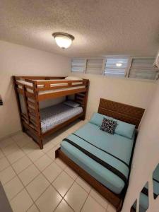 a bedroom with two bunk beds in a room at Boquerón Beach Apartment.- Guarionex 207 in Cabo Rojo