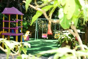 un parque infantil con parque infantil en un jardín en Merhaba Hotel, en Alanya