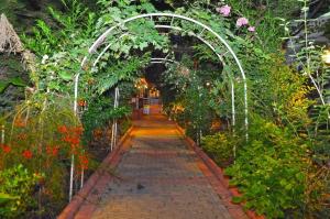 un arco en un jardín con flores y plantas en Merhaba Hotel, en Alanya 27 fotos más