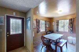 a dining room with a table and chairs and a door at Hodges Hill Yosemite House in Oakhurst