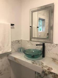 ein Badezimmer mit einem Glaswaschbecken und einem Spiegel in der Unterkunft Centrally Located Room - 5 in Port Antonio