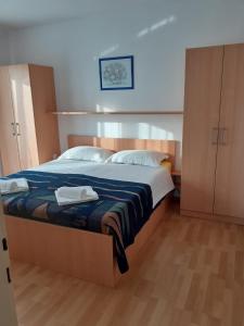 ein Schlafzimmer mit einem großen Bett mit zwei Handtüchern darauf in der Unterkunft Guest House Lucija in Rab