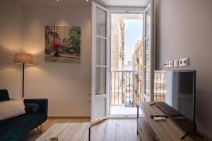 a living room with a couch and a large window at El Rincón de Fabio Little Apartments in Cádiz