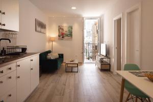 eine Küche und ein Wohnzimmer mit einem Sofa und einem Tisch in der Unterkunft El Rincón de Fabio Little Apartments in Cádiz