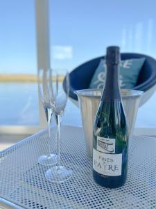 a bottle of wine and two glasses on a table at Homeboat Glamping in Nieuwpoort