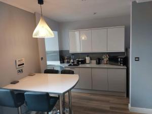 a kitchen with a table and chairs in a room at Traeth Teras (Beach Terrace) in Llandudno
