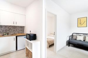 a kitchen and a bedroom with white cabinets and a bed at Casa Limoncino by Locap Group in Koper