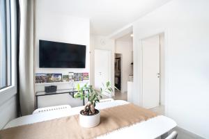 a white living room with a table and a tv at Casa Limoncino by Locap Group in Koper