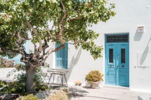 a blue door and a tree in front of a house at Captain's Quarters in Vóthon