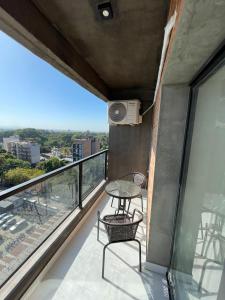 a balcony with a table and chairs and a view at Altos de Argentina in San Miguel de Tucumán
