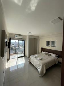 - une chambre avec un grand lit et une grande fenêtre dans l'établissement Altos de Argentina, à San Miguel de Tucumán