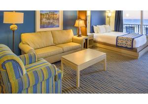 a hotel room with a couch and a bed at Dolphin Beach Club in Daytona Beach Shores +11 photos