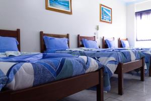 Un grupo de 4 camas en una habitación en Paradise Palace Hotel en Aparecida