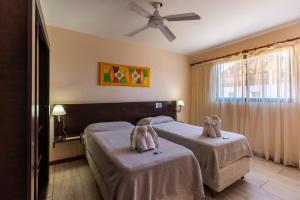 een slaapkamer met twee bedden met handdoekdieren erop bij Ayres del Bosque in Merlo