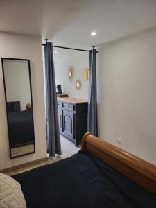 a bedroom with a bed and a large mirror at Les gîtes de ninon in Moult