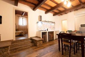 cocina con mesa y sillas y comedor en Rifugio La Foresta, en Montioni Allumiera