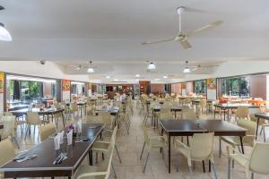 een eetkamer met tafels en stoelen en ramen bij Ayres del Bosque in Merlo