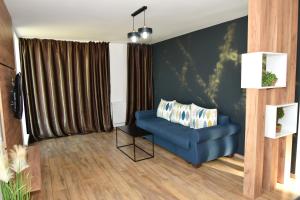 a living room with a blue couch and a window at ApartHotel Dominic Residence in Alba Iulia