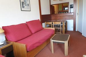 - un salon avec un canapé rouge et une table dans l'établissement 27 m avec BALCON-VUE Mont-Blanc-HYPERCENTRE, à Chamonix-Mont-Blanc