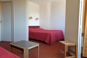 - une chambre avec un lit avec une couverture rouge et 2 tables dans l'établissement 27 m avec BALCON-VUE Mont-Blanc-HYPERCENTRE, à Chamonix-Mont-Blanc