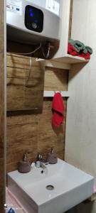 a bathroom with a white sink and a microwave at Ruralna kuća za odmor Pozojova hiža - Rural Holiday House in Lopatinec