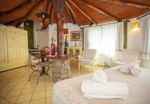 ein Schlafzimmer mit Bett und ein Wohnzimmer in der Unterkunft Cozy Studio Porto Rotondo 35 m² + Pool in Porto Rotondo