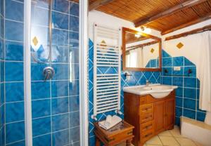 ein blau gefliestes Bad mit einem Waschbecken und einer Dusche in der Unterkunft Cozy Studio Porto Rotondo 35 m² + Pool in Porto Rotondo + 18 Fotos