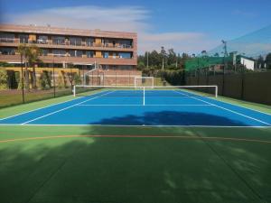 a tennis court in front of a building at Charming Apartment in Marmoiral