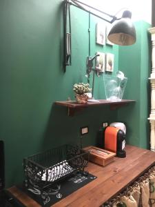 una habitación con una pared verde con una mesa y un estante en MUREX en Marsala