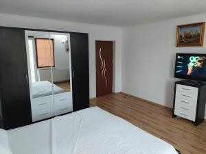 sypialnia z łóżkiem i komodą z lustrem w obiekcie Casa Doros w mieście Eforie Sud