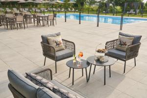 a patio with chairs and tables next to a pool at Alle Siepi in Reggio Emilia