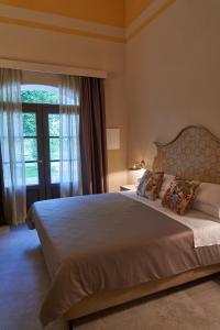 una camera da letto con un grande letto con una grande finestra di Alle Siepi a Reggio Emilia