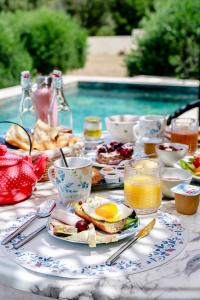 - une table avec des aliments et des boissons pour le petit-déjeuner ainsi qu'une piscine dans l'établissement U San Daniellu villas et chambres, à Farinole