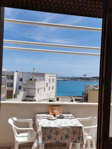una mesa en un balcón con vistas al agua en Casa Zia Gianna en Otranto