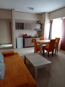 sala de estar con mesa y sillas y cocina en apartamente si studio joylife, en Costinesti