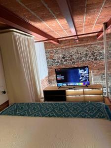 um quarto com uma cama e uma televisão de ecrã plano em 108, LOFT CONFORTABLE, BALCON 1 CALLE BELLAS ARTES em Cidade do México