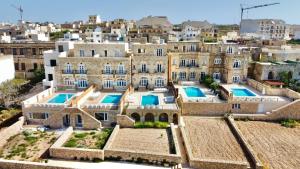 an aerial view of a building with swimming pools at Ta' Ganna Farmhouse in Sannat