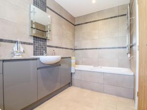 a bathroom with a sink and a tub at Chy-Whel in St Austell +13 photos