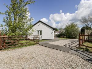 una casa blanca con una puerta y una valla en Wellfield Cottage en Highbridge