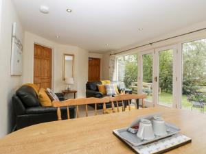 een woonkamer met een tafel en een bank bij Wellfield Cottage in Highbridge