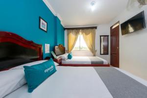 um quarto com 2 camas e uma parede azul em Ayenda La Terraza Popayán em Popayán