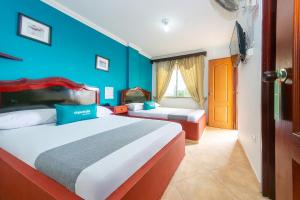 1 dormitorio con 2 camas y pared azul en Ayenda La Terraza Popayán en Popayán