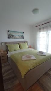 a bedroom with a large bed with two towels on it at Apartments Ulcinj in Ulcinj