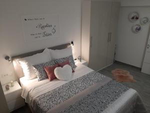 a bedroom with a large bed with pillows and a heart pillow at Apartments Bruno in Split